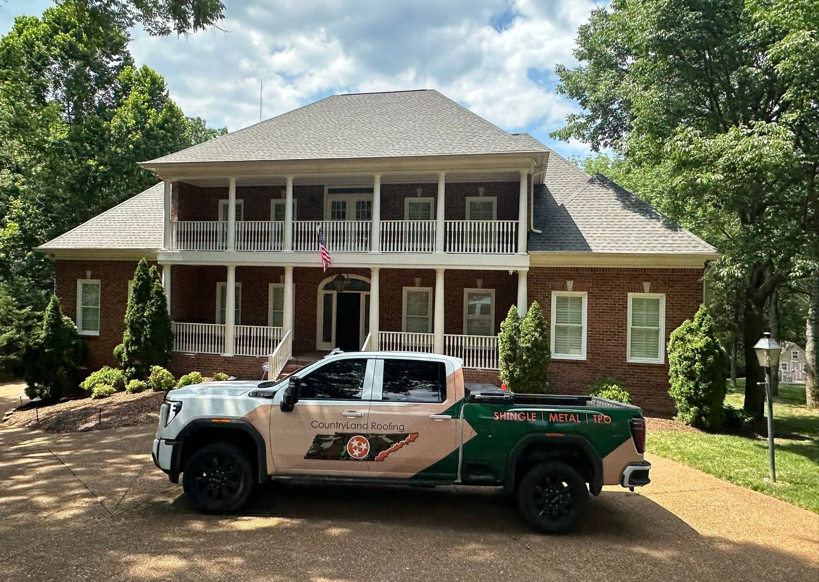 CountryLand Roofing truck at a finished roof in Middle Tennessee